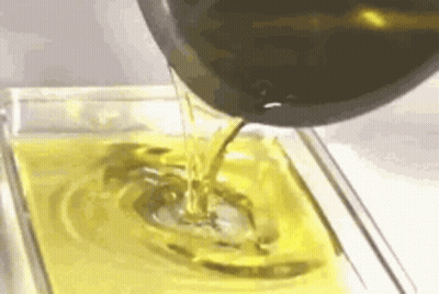 Olive Oil Is Being Poured Into A Glass Dish . GIF