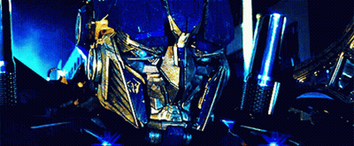 Optimus Prime And Megatron Standing Next To Each Other In Dark Room GIF