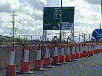 Orange And White Traffic Cones In Front Of Birmingham Business Park Sign GIF