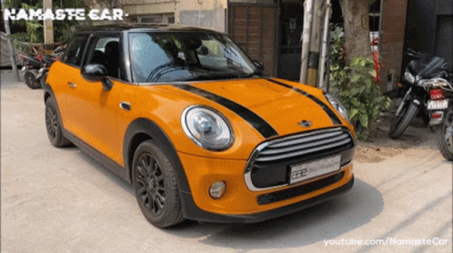 Orange Mini Cooper Parked In Front Of Building Namaste Car GIF
