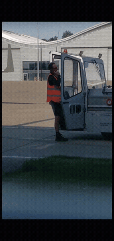 Orange Vest Man On Phone Near White Vehicle GIF