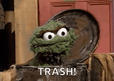 Oscar The Grouch From Sesame Street Is Sitting In A Trash Can With The Word Trash Written On It . GIF