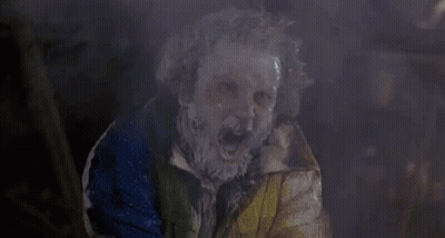 Paint-Covered Person In Clown Mask And Colorful Jacket GIF