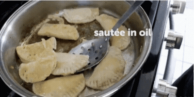 Pan Of Food Being Sauteed In Oil With Spatula GIF