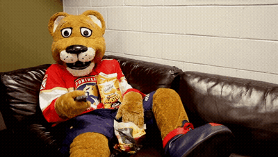 Panther Mascot Sitting On Couch With Chips GIF