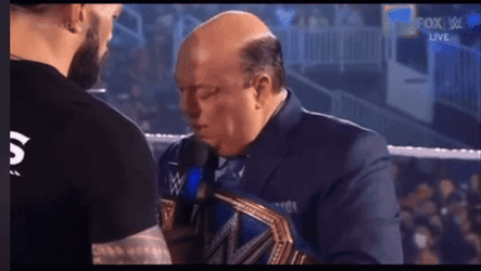 Paul Heyman Hold Face By Roman Reigns GIF
