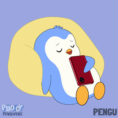 Penguin Laying On Pillow Looking At Red Cell Phone GIF