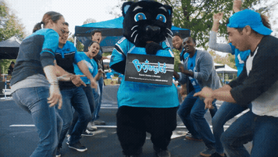 People Dancing Around Panther Mascot Holding Bojungle Box GIF