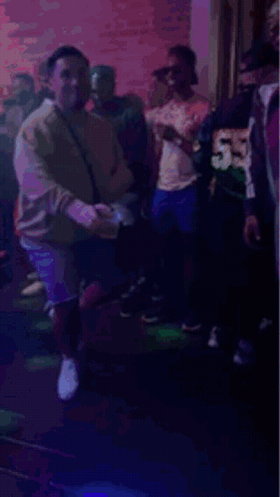 People Dancing In Club With Purple Lights GIF