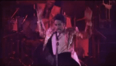 People Dancing In Dark Room In Front Of Neon Hotel Sign GIF