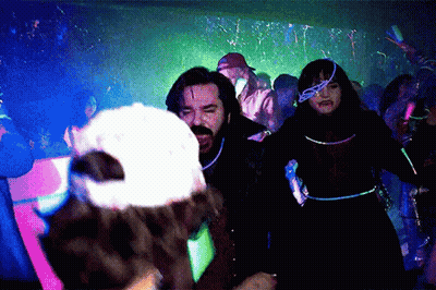 People Dancing In Dark Room With Glow Confetti GIF