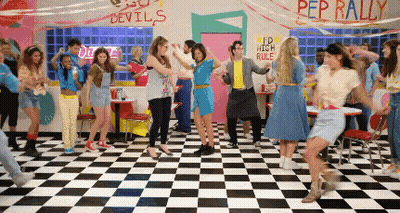 People Dancing In Diner With Pep Rally Sign GIF