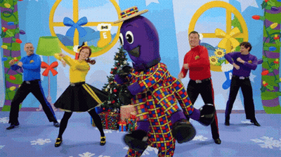 People Dancing In Front Of Christmas Tree Saying E GIF