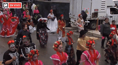People Dancing In Front Of En Vivo Sign GIF