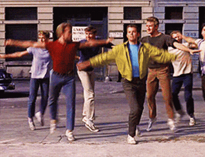 People Dancing On Sidewalk In Front Of Cart Sign GIF