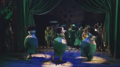 People Dancing On Stage With Green Curtains GIF