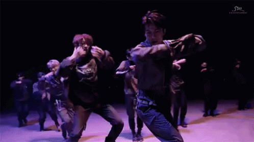 People Dancing On Stage With Purple Lights GIF