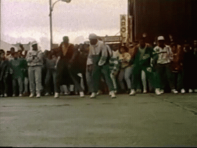 People Dancing On Street In Front Of Building GIF