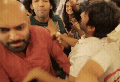 People Dancing With Man Holding Another's Arm GIF