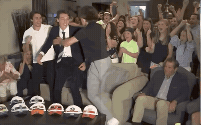 People Gathered Around Table Of Hats GIF