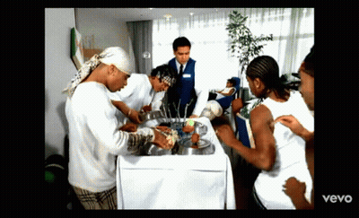 People Gathered Around Table With Vevo GIF