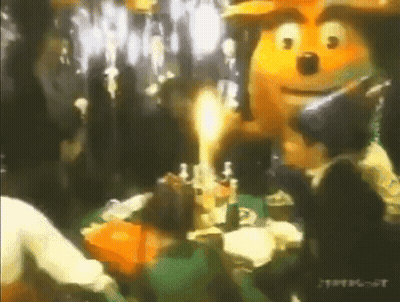 People Gathering Around Cartoon Character In Party Hat GIF