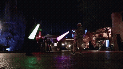 People Holding Green And Purple Light Sabers GIF
