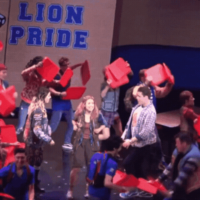 People Holding Red Buckets With Lion Pride Sign GIF