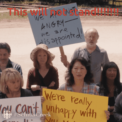 People Holding Up Signs Saying This Will Not Stand GIF
