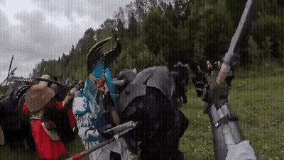 People In Costumes Holding Swords And Shields GIF