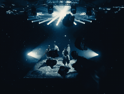 People In Dark Room With Light Through Ceiling GIF