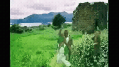People In Grassy Field By Building GIF
