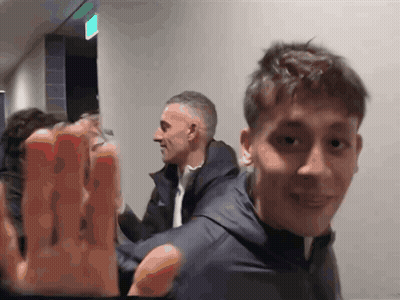 People In Hallway With Green Exit Sign GIF