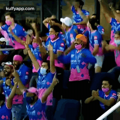 People In Masks Watching Cricket At Stadium GIF