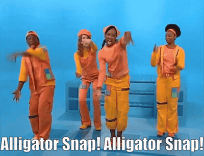 People In Orange And Yellow Jumpsuits Dancing With Alligator Snap GIF