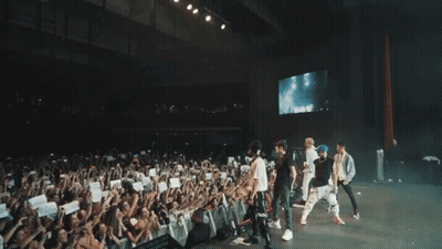 People On Stage With Smoke And Crowd GIF