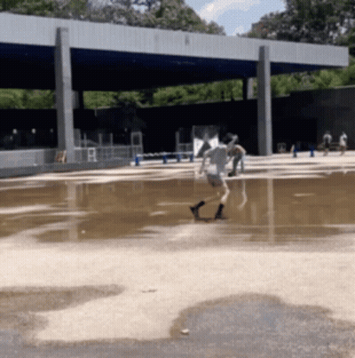People Playing In Large Puddle Of Water GIF