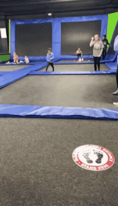 People Playing On Trampoline With Stand Here Sign GIF