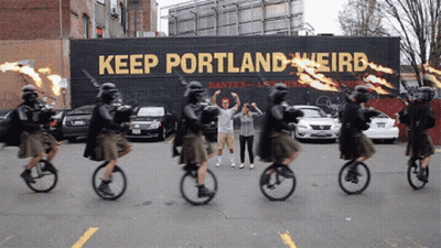 People Riding Bicycles Past Keep Portland Weird Sign GIF