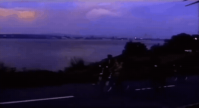 People Riding Bikes On Road Near Water GIF