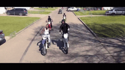 People Riding Dirt Bikes Down Street GIF