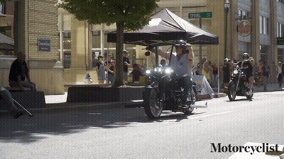 People Riding Motorcycles On Street With Motorcyclist Text GIF