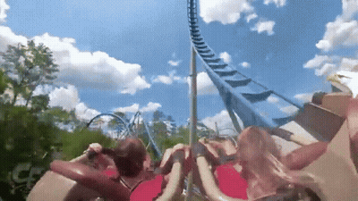 People Riding Roller Coaster With Blue Sky And Clouds GIF