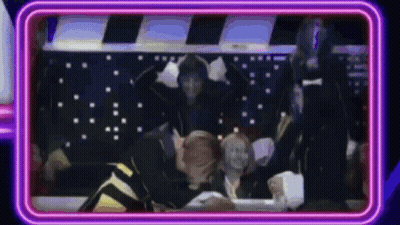 People Sitting Around Table With Neon Sign GIF