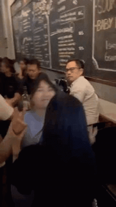 People Sitting At Table In Front Of Chalkboard GIF