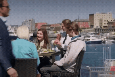People Sitting At Table In Harbor GIF
