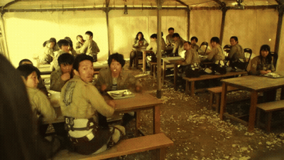People Sitting At Tables Under Tent Eating GIF