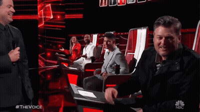People Sitting In Chairs On Stage With NBC Logo GIF