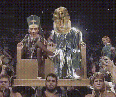 People Sitting In Front Of King And Queen Statue GIF