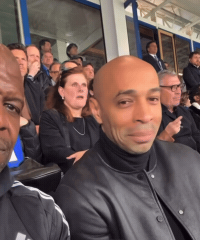 People Sitting In Stadium With Bald Man GIF